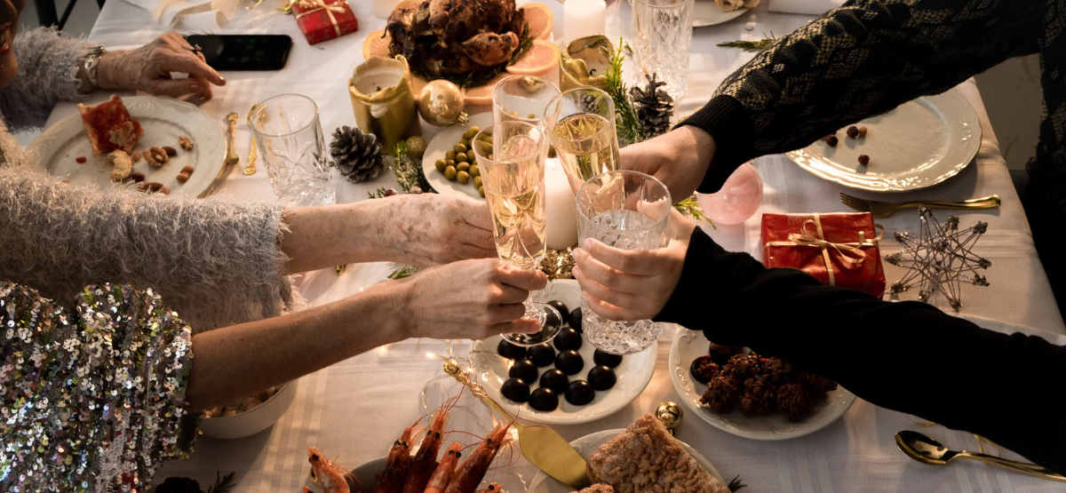 People cheering glasses over holiday table